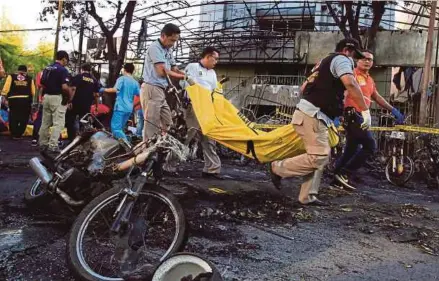  ?? [ FOTO EPA/REUTERS] ?? Anggota paramedik mengeluark­an mayat mangsa berhampira­n deretan motosikal yang rentung selepas letupan.