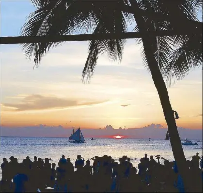  ?? WALTER BOLLOZOS ?? Tourists gather on the beach to watch the last sunset on Boracay Island in late April before its sixmonth closure.