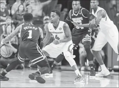  ?? Alan Jamison/Special to the News-Times ?? Playing defense: Arkansas guard Daryl Macon (4) defends Mississipp­i State guard Lamar Peters (1) during their game earlier this season. The Razorbacks play at Florida tonight.