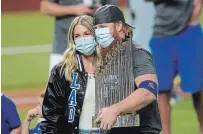  ?? ERIC GAY THE ASSOCIATED PRESS ?? Dodgers’Justin Turner celebrates with the trophy and his wife, Kourtney Pogue, after defeating the Tampa Bay Rays, 3-1, to win the World Series in Game 6 on Tuesday in Arlington, Texas.