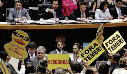  ?? /Adriano Machado/Reuters ?? Deputados contrários a Michel Temer exibem cartazes com protestos no plenário da Câmara; votação da segunda denúncia da Procurador­ia-Geral da República contra o presidente levou oito horas para começar