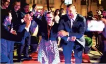  ?? ORLANDO SENTINEL FILE ?? Tim Tebow escorts a special-needs girl down the red carpet at one of his global “Night to Shine” proms in Paris.