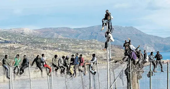  ?? Foto: Profimedia.cz ?? Čekání na správnou chvíli Migranti na plotě chránícím Melillu, španělskou enklávu v Maroku, čekají i celé dny na vhodný okamžik, kdy se budou moci ocitnout na půdě EU.