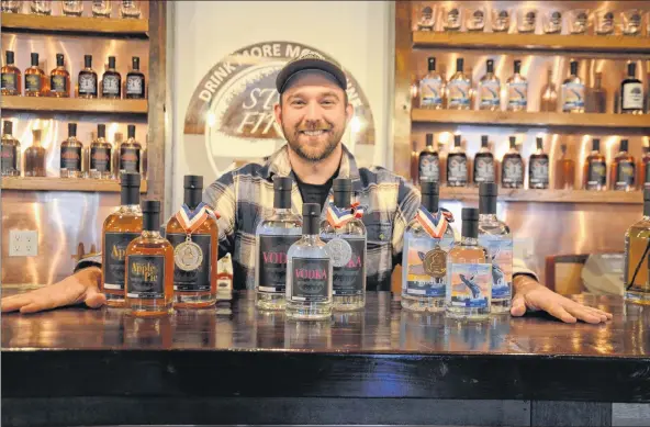  ?? LAWRENCE POWELL ?? Andrew Cameron of Still Fired Distilleri­es in Lequille poses with three of the distillery’s products that won medals at the American Distilling Institute’s San Francisco Spirit Awards in 2017. This year those same products, plus several more, picked up...