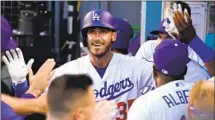  ?? Mark J. Terrill Associated Press ?? CODY BELLINGER is greeted by teammates in the dugout after hitting a second-inning home run, the Dodgers’ lone run.