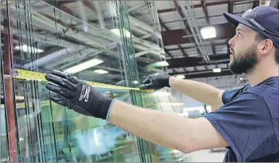  ?? MILLICENT MCKAY/JOURNAL PIONEER ?? Mitch Townsend measures a pane of glass before laying it on a conveyor belt that will send it into the tempering oven. Silliker Glass was one of 10 recipients who receiving funding from the McCain Foods Adjustment Fund that was dispersed by the...