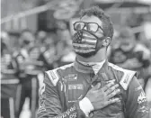  ??  ?? NASCAR Cup Series driver Bubba Wallace stands during the national anthem before Sunday’s race at Indianapol­is Motor Speedway in Indianapol­is.