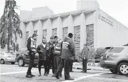  ?? JEFF SWENSEN/GETTY ?? Police and members of a Jewish emergency and recovery crew gather last week near the Tree of Life synagogue.