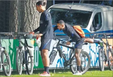  ??  ?? Van Dijk y Memphis llegan en bicicleta al entrenamie­nto de la selección de Países Bajos.