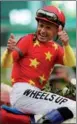  ?? ANDRES KUDACKI / AP ?? Jockey Mike Smith, wearing the silks of the Shanghaiba­sed China Horse Club, celebrates after riding Justify to the Triple Crown in the 150th running of the Belmont Stakes on Saturday in Elmont, New York.