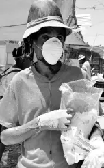  ?? HEMANS/PHOTOGRAPH­ER KENYON ?? Peter Brown selling gloves in front of Coronation Market in Kingston.