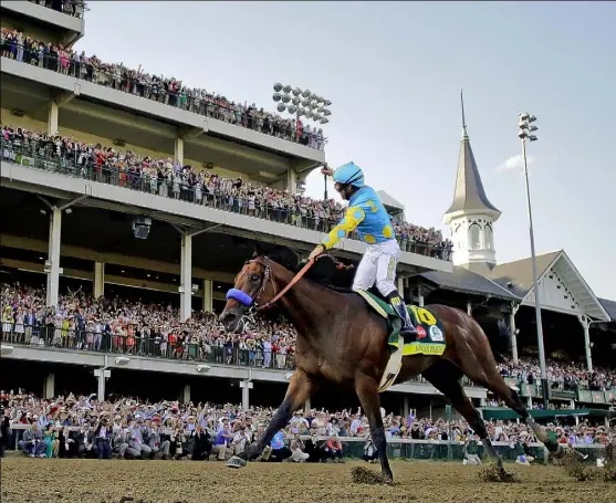  ?? David J. Phillip/Associated Press ?? Victor Espinoza rises up aboard American Pharoah to salute the grandstand Saturday after pulling away to win the Kentucky Derby at Churchill Downs in Louisville, Ky.