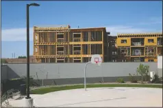  ??  ?? New residentia­l constructi­on rises next to a basketball court at a middleclas­s neighborho­od in Phoenix on March 9.