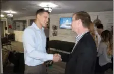  ?? SARATOGA COUNTY CHAMBER OF COMMERCE PHOTO ?? Jeremiah Cregan of Saving Face Barbershop, left, shakes hands with Saratoga County Chamber of Commerce president Todd Shimkus, right, during the shop’s ribbon-cutting and grand opening event.