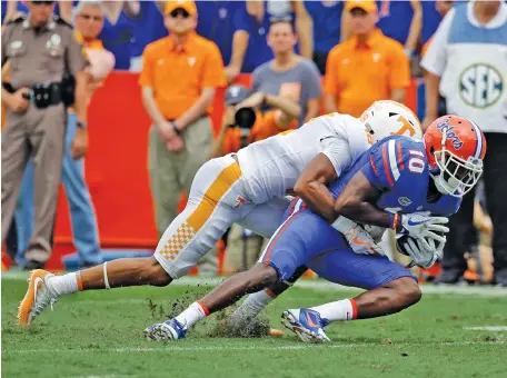  ?? THE ASSOCIATED PRESS ?? Florida wide receiver Josh Hammond (10) is tackled by Tennessee safety Nigel Warrior during the first half Saturday in Gainesvill­e, Fla.