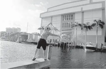  ?? MIKE STOCKER/SOUTH FLORIDA SUN SENTINEL ?? Greg Octavec throws a net to catch some bait before launching his boat Wednesday at Cox’s Landing in Fort Lauderdale.