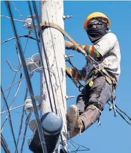  ?? FILE ?? A Jamaica Public Service Company crewman removes wires from a utility pole.