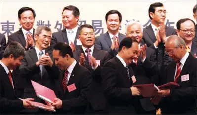  ?? PARKER ZHENG / CHINA DAILY ?? Wang Zhongbing (2nd left, 2nd row), mayor of Zhanjiang in Guangdong province, witnesses a contract-signing ceremony during the Zhanjiang (Hong Kong) Investment Promotion Conference at the Hong Kong Convention and Exhibition Centre on Thursday.