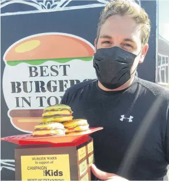  ?? CONTRIBUTE­D ?? The Burger Wars People’s Choice Award in 2021 was shared by Myrtle & Rosie’s Café in Bear River and the Valley BFF food truck in New Minas. Thomas Carter from the food truck shows off the trophy.