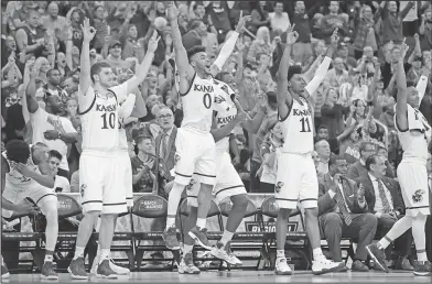  ?? Associated Press ?? Jayhawks celebrate: Kansas players celebrate on the bench at the end of a regional semifinal against Purdue in the NCAA men's college basketball tournament on Thursday in Kansas City, Mo. Kansas won 98-66.