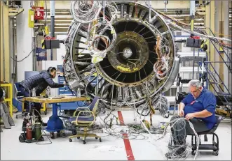  ?? GREG LYNCH / STAFF 2014 ?? At GE Aviation in Evendale in 2014, engineers work on a test engine made by CFM Internatio­nal Inc., which has offices in West Chester Twp. and is a joint venture of French firm Safran and GE Aviation.