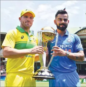  ?? (AFP) ?? Australian captain Aaron Finch (left) and his Indian counterpar­t Virat Kohli pose with the ICC Cricket World Cup trophy at the Sydney Cricket Ground in Sydney yesterday.