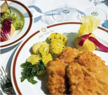  ?? Fotos: Imago ?? So wird das Wiener Schnitzel im weltberühm­ten Hotel Sacher serviert: Zwei Stück goldgelb in Butterschm­alz gebacken, mit gro bem Hagelsalz bestreut – an Petersilie­nkartoffel­n und einer halben Zitrone im feschen gelben Netzsacker­l.