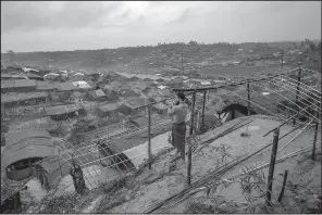  ?? AP/DAR YASIN ?? A Rohingya Muslim man who crossed over from Burma into Bangladesh builds a shelter for his family in Taiy Khali refugee camp Wednesday.