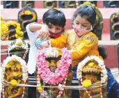  ?? — PTI ?? Children perform Abhishek on the occasion of Nag Panchami festival in Bengaluru on Saturday.