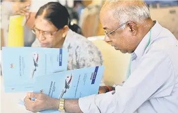  ?? — Reuters photo ?? Family members read MH370 briefing reports before a closed door meeting in Putrajaya.