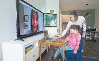  ?? NATHAN DENETTE THE CANADIAN PRESS FILE PHOTO ?? Kristy Denette helps her daughter Peyton, 6, on speech and language skills with pathologis­t Olivia Chiu remotely.