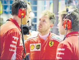  ?? FOTO: EFE ?? Vettel, de charla con sus ingenieros en Singapur. El alemán cree en el ‘milagro’