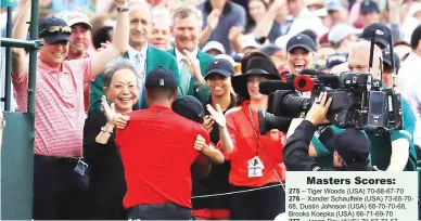  ?? (AFP) ?? WHAT A FEELING – Tiger Woods celebrates with his son Charlie Axel, his mother Kultida, and daughter Sam Alexis as he leaves the 18th green after winning the Masters at Augusta National Golf Club last Sunday in Augusta, Georgia.