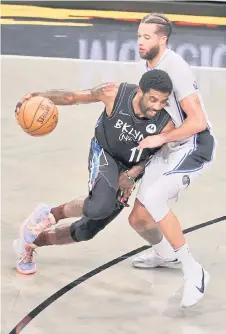  ?? — AFP photo ?? Kyrie Irving (left) of the Brooklyn Nets drives against Michael Carter-Williams of the Orlando Magic during their game at the Barclays Centre in New York City.