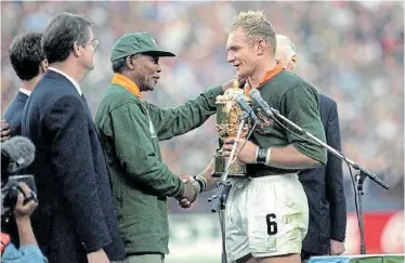  ?? Picture: ROSS KINNAIRD/PA IMAGES/via GETTY IMAGES ?? ‘FRANCOIS, THANK YOU’: World Cup-winning Springbok Francois Pienaar receives the William Webb Ellis Trophy from President Nelson Mandela at Ellis Park in Johannesbu­rg on June 24 1995