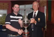  ??  ?? Tough test: Thomas O’Connor (Athlone) receives the Ulster Mid-Amateur trophy from Eamonn O’Connor (Ulster Branch)