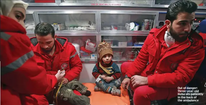  ??  ?? Out of danger: Three-year-old Heba sits patiently in the back of the ambulance