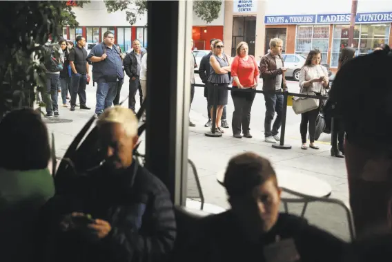  ?? Scott Strazzante / The Chronicle ?? Attendees wait in line outside the Tech Jobs Tour stop at the Grand Theater in San Francisco on Wednesday. The Oakland event of the 50-city tour is Dec. 6.