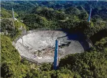  ?? Ricardo Arduengo / AFP via Getty Images ?? The Arecibo Observator­y’s radio telescope collapsed after one of the main cables holding the receiver broke Tuesday.