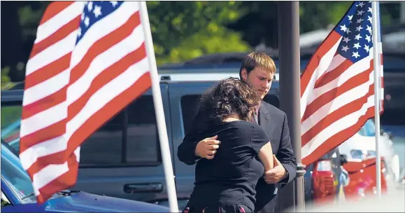  ??  ?? Steven Kesner of Lockport comforts Elise Masciale of Palatine, both 23, after attending the public visitation for John Larimer.
| RICHARD A. CHAPMAN~SUN-TIMES