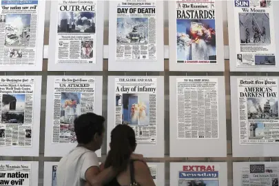  ??  ?? Dos visitantes del Newseum de Washington contemplan un mural con portadas relativas a los atentados del 11-S en Nueva York.