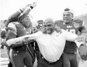  ?? ALBERT CESARE/ASSOCIATED PRESS ?? KJ Miles, left, and Chris Oladokun celebrate with coach Charlie Strong after USF’s thrilling bowl win Saturday.
