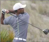  ?? The Associated Press ?? LONG WAY BACK: Tiger Woods, here driving off No. 3 in the third round, falls 11 shots behind leader Hideki Matsuyama in the Hero World Challenge after a 2-under 70 on Saturday.