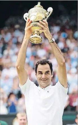  ?? CLIVE BRUNSKILL / GETTY ?? El suizo Roger Federer levanta el trofeo de campeón