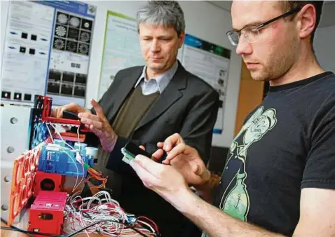  ??  ?? Abteilungs­leiter Rainer Heintzmann und Christian Karras, wissenscha­ftlicher Mitarbeite­r am IPHT, testen eine neue Funktion an einem der Smartphone-Mikroskope. Das Baukastens­ystem erlaubt variable Konstrukti­onsaufbaut­en. Die Forschunge­n wurden vom...