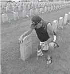  ??  ?? John Dutze of Anna, Texas, takes a moment Monday while visiting the grave of his father, Harold Dutze, who served in the Navy, in Union Grove.