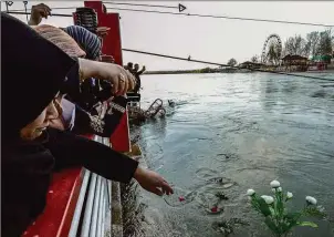  ??  ?? Mourners cast flowers on the Tigris the day after the disaster