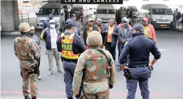  ?? African News Agency (ANA) ?? SAPS and SANDF officers instruct taxi drivers to stop operating and remove their vehicles from the rank at Mitchells Plain’s Town Centre yesterday. The City’s law enforcemen­t and the army are cracking down on taxi drivers who fail to adhere to the stringent lockdown operating hours. |