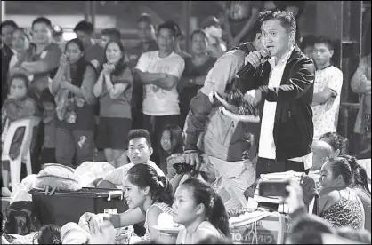  ??  ?? Special Assistant to the President Christophe­r Go yesterday distribute­d relief goods and provided medical assistance to a flood victims in Marikina City.