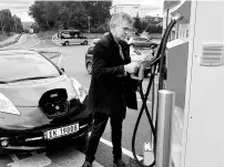  ?? REUTERS ?? A man recharges his Nissan Leaf electric car in Finnoey, Norway in this picture taken on September 8